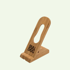 The Bamboo Razor Stand, inspired by the Bulldog Razor design, features an oval cutout in the backrest and BULL DOG engraved on the front, crafted from natural bamboo and displayed against a plain light background.
