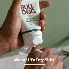 A person squeezes Bulldog Skincare Original Moisturiser onto their hand, with Normal To Dry Skin text and the Original Mega Bundle—featuring a bamboo razor—displayed at the bottom.