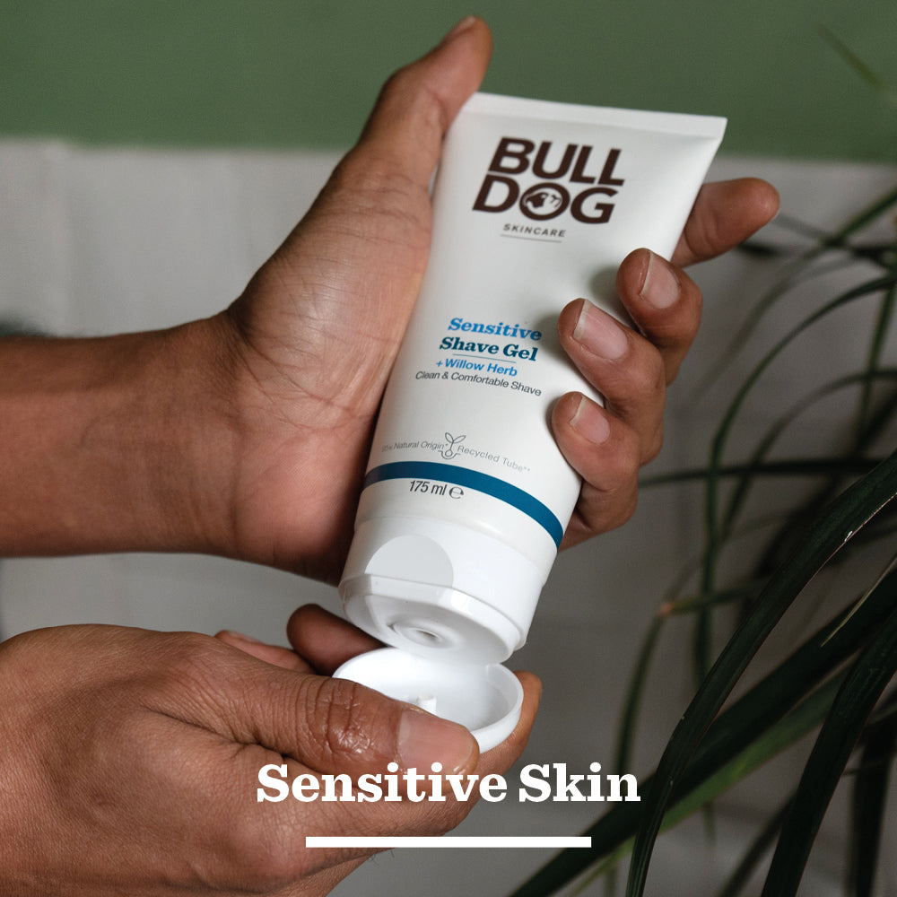 A person dispenses Sensitive Shave Gel for men onto their hand, with the tube labeled for sensitive skin. Text at the bottom reads Sensitive Skin.