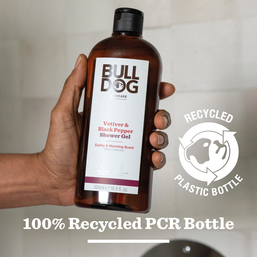 A hand holds a bottle of Vetiver & Black Pepper Shower Gel. Text highlights its 100% recycled plastic bottle (recycled symbol), natural fragrance, and commitment to men’s skincare.