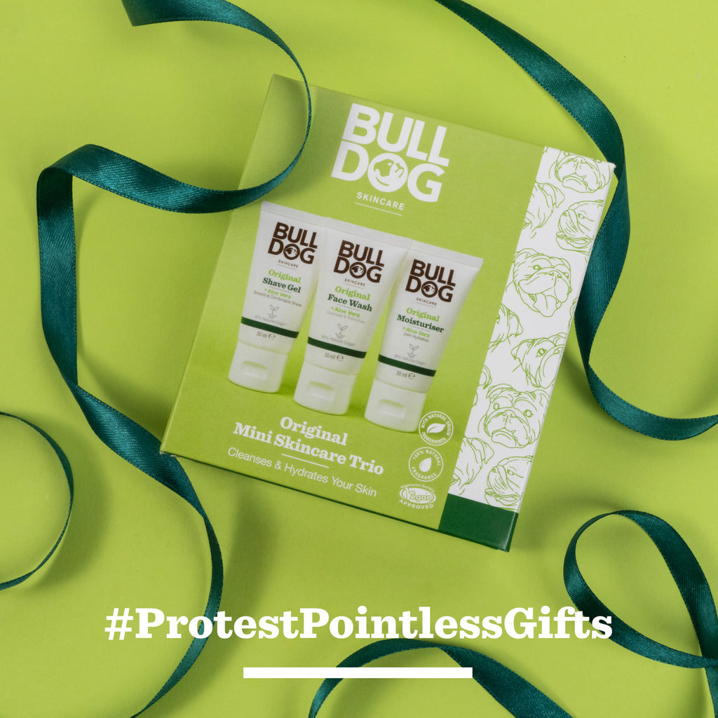 A green box of the Original Mini Skincare Trio sits centered on a green background with a dark green ribbon. White text at the bottom reads: #ProtestPointlessGifts.