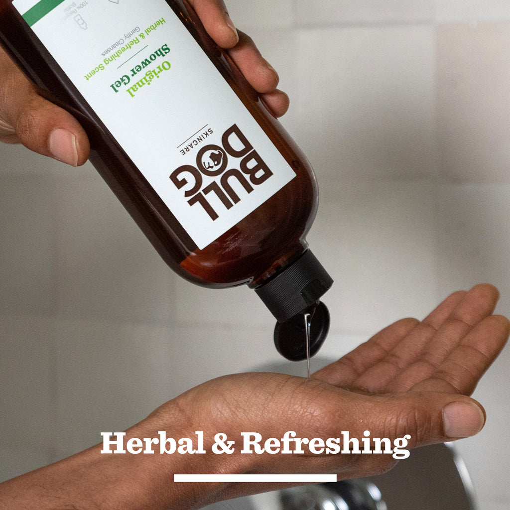 A person pours shower gel from a brown bottle labeled Original Grooming Kit onto their hand. The image features the text Herbal & Refreshing below, emphasizing this essential grooming product.